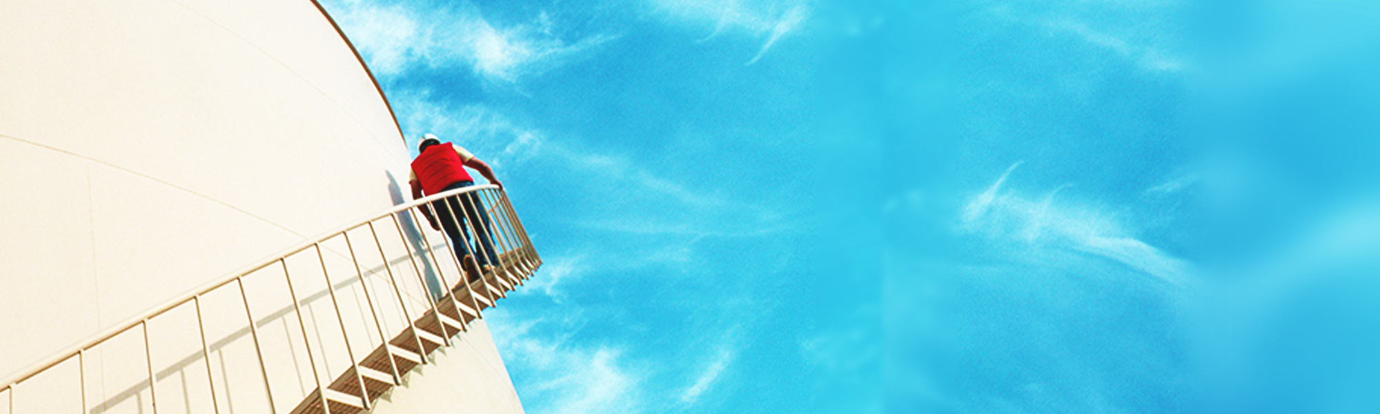A person climbing the stairs outside the natural gas tank